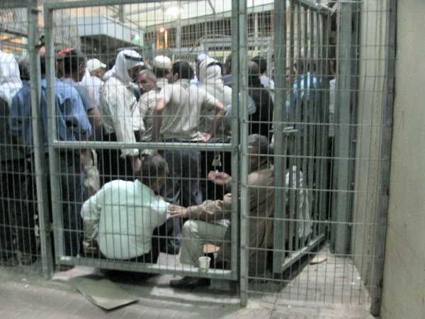 Men jammed up at the top end of the first ramp waiting for the turnstile to open